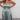 Shimmery silver strapless metallic jumpsuit worn by a model, showcasing evening party wear with an elegant, form-fitting design that highlights the shoulders and legs.