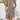 A woman wearing a short summer dress with a geometric print, featuring a keyhole neckline and tassels.