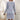 Women's silver ribbed long sleeve knit sweater dress featuring a stylish backless design, perfect for winter fashion. The dress showcases a fitted silhouette with a subtle textured pattern across the fabric.