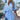 Striped blue blouse dress featuring a ruffled hem and drawstring waist, modeled by a person smiling, showcasing the dress with a focus on the shoulder and hem details.