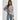 Striped blue and white knit cardigan styled as a casual chic button-up sweater, worn by a person with black hair, featuring a focus on the shoulder and neck area.