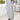 Lightweight summer pajamas featuring striped button-up lounge pants; model standing next to a table with a plant, showcasing the leg design.