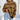 Tan and black striped chunky turtleneck sweater with long sleeves, designed for casual winter wear, styled on a mannequin showing shoulder and neck details.