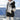 Striped fleece women's hooded Sherpa jacket in a warm colorblock design, worn by a person outdoors in a snowy environment. The jacket features a plush texture and includes sleeves and a hood, providing warmth and comfort.