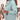 Stylish women's light blue oversized winter coat showcasing its chic outerwear design, with a focus on the shoulder and sleeve detailing. The coat drapes elegantly, emphasizing the fashion-forward style suitable for cold weather, while a handbag is subtly included in the image.