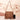 Tan suede crossbody bag with fringe tassels and a boho design, featuring a shoulder strap and hobo bag style suitable for festivals.