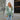 Teal long sleeve knit cardigan worn over a white dress shirt, paired with jeans. The cardigan features a classic collar and is styled as a fashionable fall layering piece.