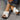 Trendy green women's flat sandals featuring a bow-tie design, worn on a woman's foot against a blue background, showcasing a fashionable beachwear style.