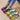 Multicolor sneakers featuring a vibrant rainbow sole with a blend of blue, yellow, and electric blue accents, designed for fashion-forward walking and outdoor activities.