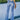 Trendy women's high-waisted light wash button-fly skinny jeans in a light blue color.