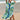 Woman wearing a tropical print green beach kaftan, standing near water, showcasing the lightweight V-neck summer dress in an outdoor setting.
