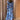 Whimsical blue maxi dress featuring colorful embroidery and patterns, showcasing shoulder and neck details, with a fitted waist and long sleeves.