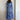 Whimsical blue maxi dress featuring vibrant colorful embroidery and patterns, displayed on a clothes hanger, showcasing its one-piece design with emphasis on the neckline, sleeves, and waist.