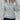 White cable knit zip-up sweater worn by a woman, showcasing a stylish autumn pullover with a focus on the detailed knit pattern and zipper front, set against a minimalist background.