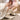 White embroidered women's western cowboy boots displayed on a model, showcasing intricate detailing and chic fashion style.