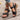 White floral wedge sandals featuring a beaded strap and intricate cutout design.