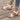 White floral wedge sandals featuring a beaded strap and cutout design, worn on a person's foot.
