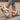 White floral wedge sandals featuring a beaded strap and intricate cutout design.