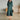 White linen midi dress featuring a V-neck, pleated design, and long sleeves, emphasizing a sustainable fashion choice.
