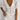 White linen mini dress with short sleeves, a collar, and a fitted waist, displayed on a hanger.