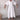 White linen V-neck dress with mid-length hem, featuring short sleeves and a flattering waistline. The dress is worn by a smiling person, showcasing the dress's casual summer style.