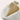 White quilted insulated lightweight winter snow boots on a wooden surface, showcasing their fashionable and comfortable design in beige color.