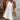 White sleeveless eyelet halter dress suitable for casual or beachwear, featuring knee-length design with a focus on the neck and shoulder details.