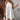 White sleeveless eyelet halter dress, knee-length, suitable for casual and beachwear occasions, displayed on a standing mannequin or model.