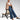 Wide-leg high-waisted jeans paired with a neutral blazer, showcasing a casual chic outfit with visible footwear and dress shirt sleeves.
