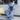 Wide-leg vintage denim overalls with trendy casual chic design, featuring adjustable shoulder straps, front pocket, and relaxed fit, modeled by a person wearing a grey blazer and eyewear.