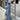 Woman wearing wide-leg vintage denim overalls with adjustable shoulder straps, showcasing a trendy casual chic jumpsuit style.