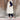 Women's beige hooded puffer vest displayed on a model, showcasing a stylish sleeveless winter coat design, paired with casual footwear and clothing.