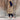 Beige hooded puffer vest for women, featuring a stylish sleeveless design suitable for winter, paired with denim pants.