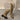 A pair of women's beige suede knee-high boots with a slouchy design and block heels, displayed on a wooden floor.