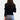 Woman wearing a black V-neck cardigan with gold buttons, styled for chic office wear.