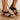 Women's black wedge sandals with elegant floral embroidery detail, combining comfort with stylish fashion.
