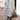 Women's black hooded oversized puffer coat styled for urban street fashion, showcasing its quilted design and relaxed fit with sleeves and waist details visible.