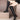 Women's black knee-high leather boots featuring a tassel and a sturdy block heel.