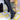 Women's black knee-high leather boots with tassel detail and block heel, showcasing a sleek and stylish design.