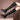 Women's black knee-high leather boots featuring tassels and a block heel, worn on a model's legs.