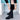 Women's black knee-high leather boots with tassel detail and block heel, showcasing fashion-forward design.