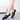 Women's black leather platform loafers on feet, showcasing the comfortable and stylish design.