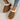 Women's black shearling fuzzy lined platform loafers on a wooden floor with a beige background, showing the shoe's elevated wedge design and comfortable lining.