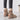 Women's black suede ankle boots with fur lining, designed for winter wear and non-slip functionality, shown on a wooden floor.