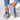 Women's blue denim slip-on sneakers featuring cat embroidery design, shown worn on a foot against a white background.