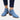 Women's blue suede ankle boots with a pointed toe and mid-heel, styled with denim jeans.