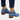 Women's blue suede ankle boots with a pointed toe and mid-heel, worn with dark denim jeans.