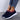 Women's breathable mesh slip-on sneakers shown on a person's feet wearing denim shorts, highlighting the lightweight and comfortable design suitable for summer wear.