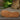 Women's brown wedge loafers styled as casual sneakers with a synthetic rubber sole, displayed outdoors on grass.