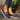 Women's brown wedge loafers with a stylish casual design, featuring a textile upper and denim accents, displayed on a surface with a natural backdrop.